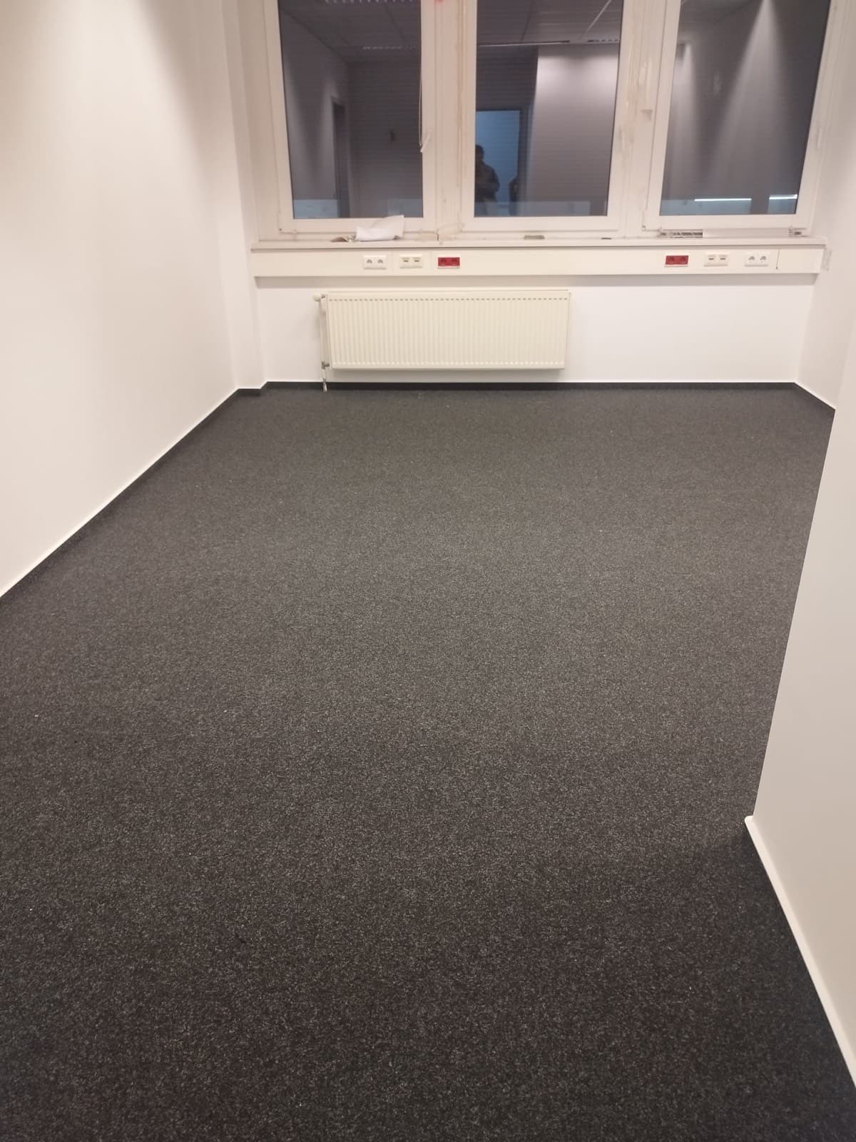 Fertig verlegter anthrazitfarbener Teppichboden in einem Büroraum