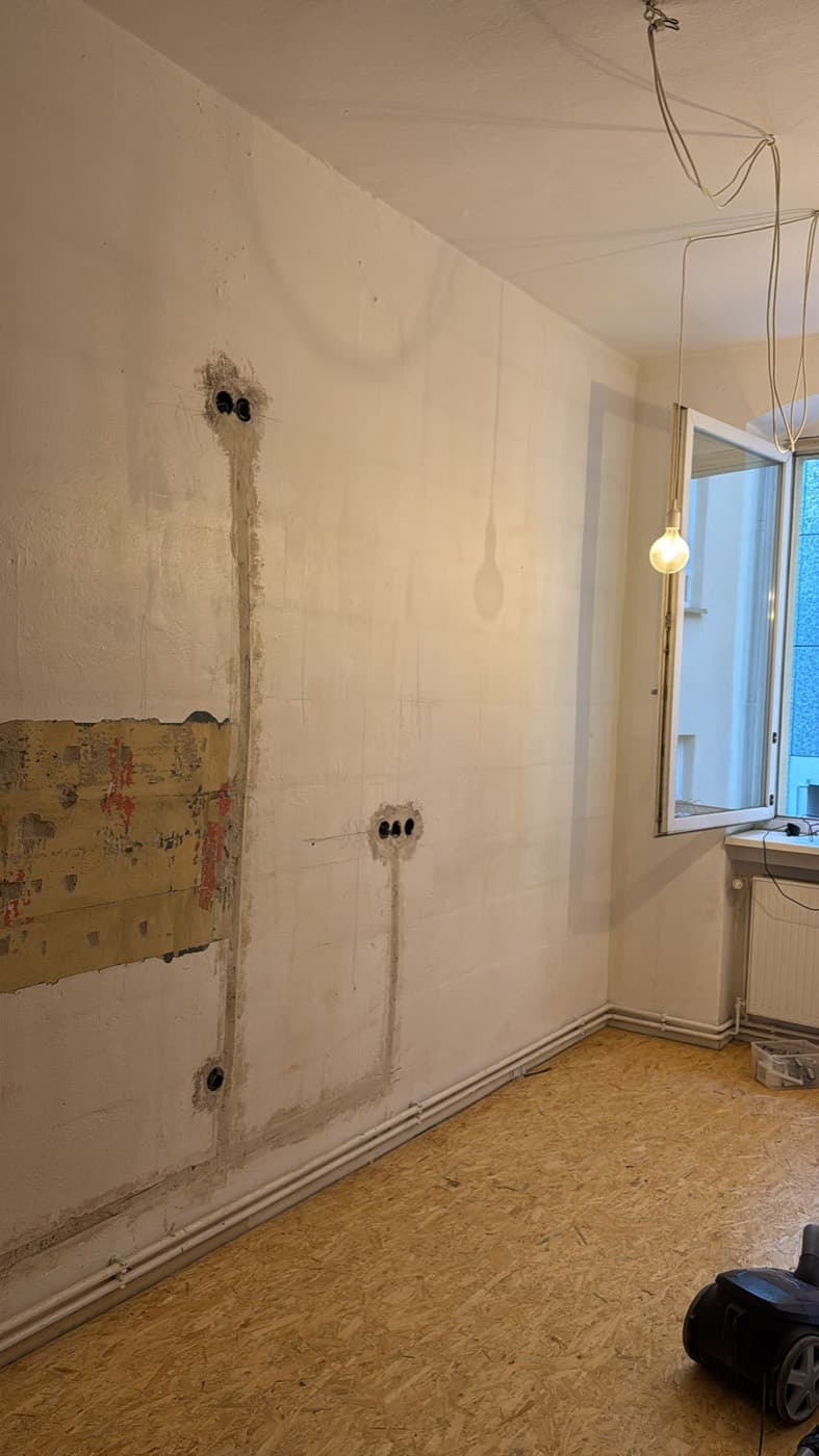 Entkernter Raum mit aufgestemmten Elektroschlitzen und OSB-Boden